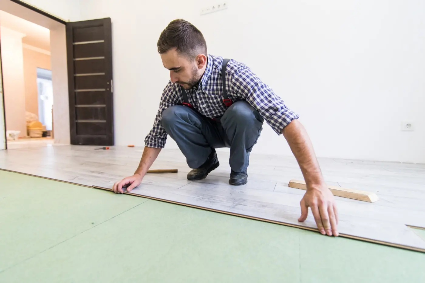 Worker installing residential plank flooring