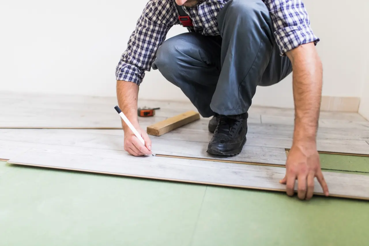 Worker installing residential plank flooring
