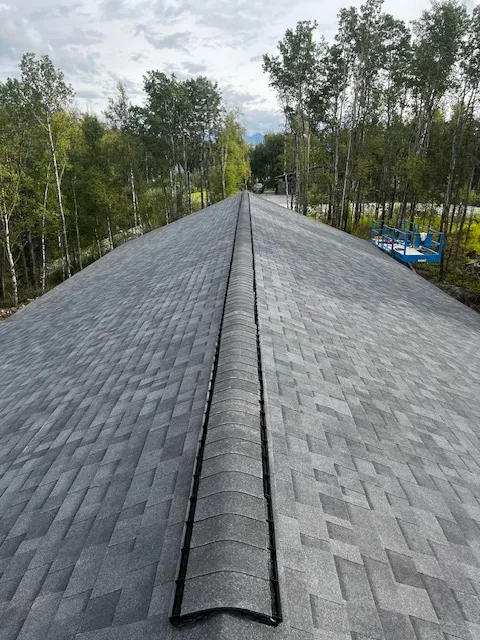 Ridge cap detail along a newly shingled roofline
